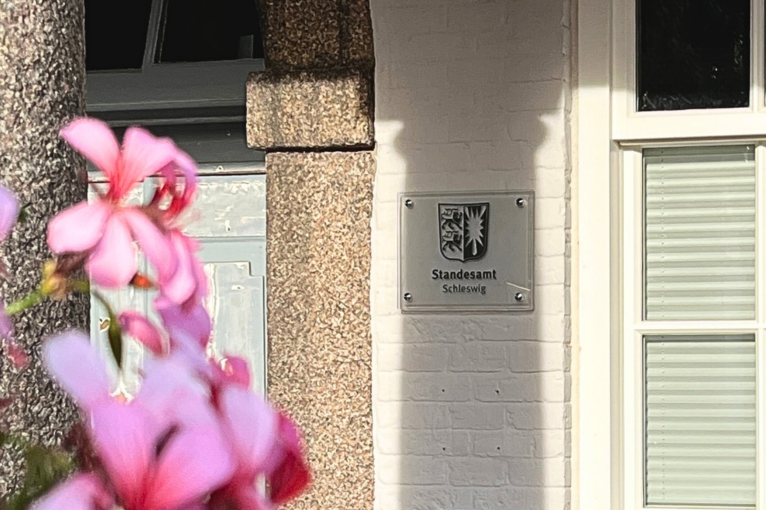 Eingang zum Standesamt mit pinken Blumen im Vordergrund