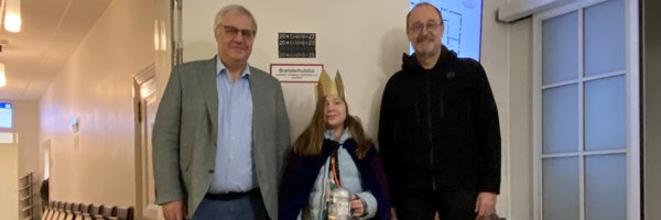 Stephan Dose, Matilda Zydek und Pastor Karsten Winter stehen vor der Rathaustür mit dem Aufdruck 20*C+M+B+25