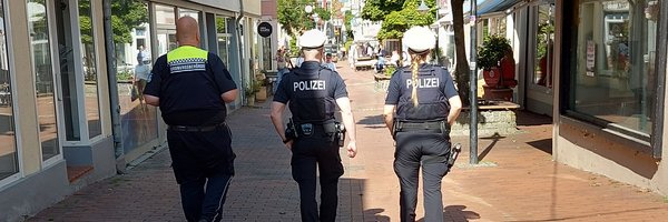 Gemeinsame Kontrolle von drei Personen der Polizei und Kommunaler Ordnungsdienst von hinten mit Blick in die Innenstadt, Stadtweg in Schleswig