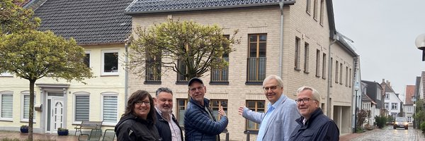Anja Friedrich (Stadt Schleswig), Dipl. Ingenieur Peter Paustian (HochbauPlanung Paustian), Robert Davids (Gesellschafter Lorenzen Bauunternehmen GmbH) und Stephan Dose sowie Bernward Völmicke (Stadt Schleswig) vor dem Neubau Töpferstr. 14 -