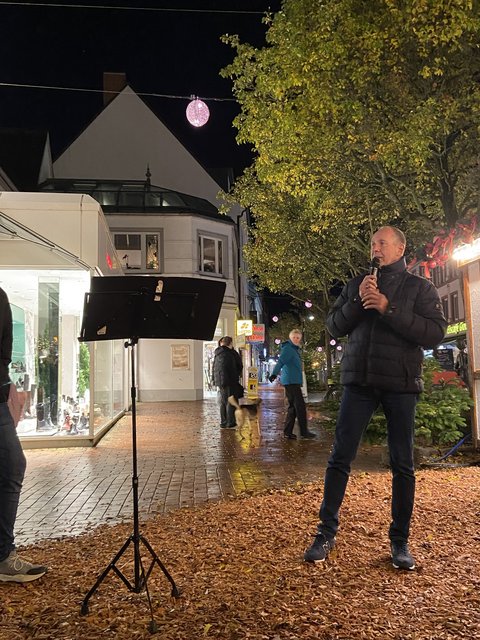 Stellvertretender Bürgermeister Rainer Haulsen auf dem Weihnachtsmarkt mit einem Mikrofon in der Hand