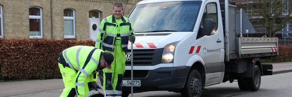 Bild zeigt Mitarbeitende der Stadtwerke SH bei der Reparatur eines Schlagloches in der Moltkestraße mit Kaltasphalt