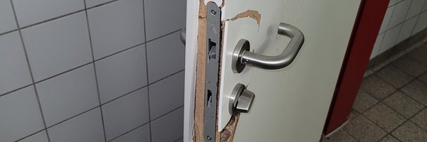 Bild zeigt defekte Toilettentür im Parkhaus aufgrund von Vandalismus