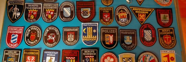 Vitrine im Klassenzimmer zeigt Abzeichen/Aufnäher, u. a. der Stadt Schleswig für deutsch-französisches Bildungsprojekt