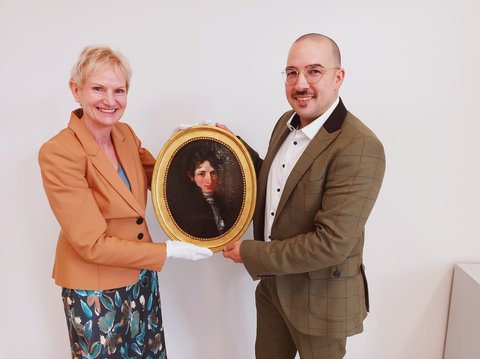 Das Schleswiger Stadtmuseum wird seit Jahrzehnten von der Fielmann Group AG unterstützt. Diesmal brachte der Leiter der Schleswiger Fielmann-Niederlassung, Jonas Gropp, ein Porträtgemälde von der Hand des Malers Conrad Christian August Böhndel aus dem Jahr 1812 als Geschenk mit.