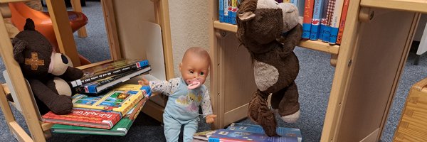 Kuscheltiere zwischen Büchern in der Stadtbücherei