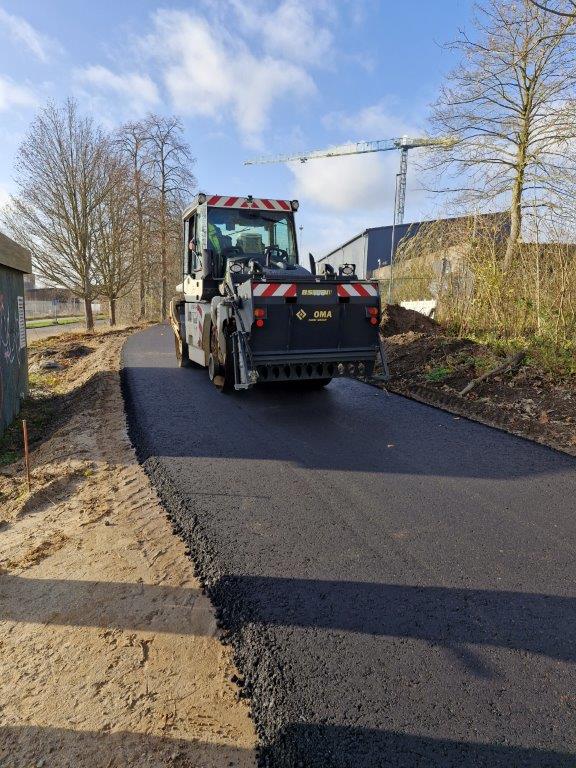Die Walze verdichtet die Asphalttragschicht auf der Trasse. 