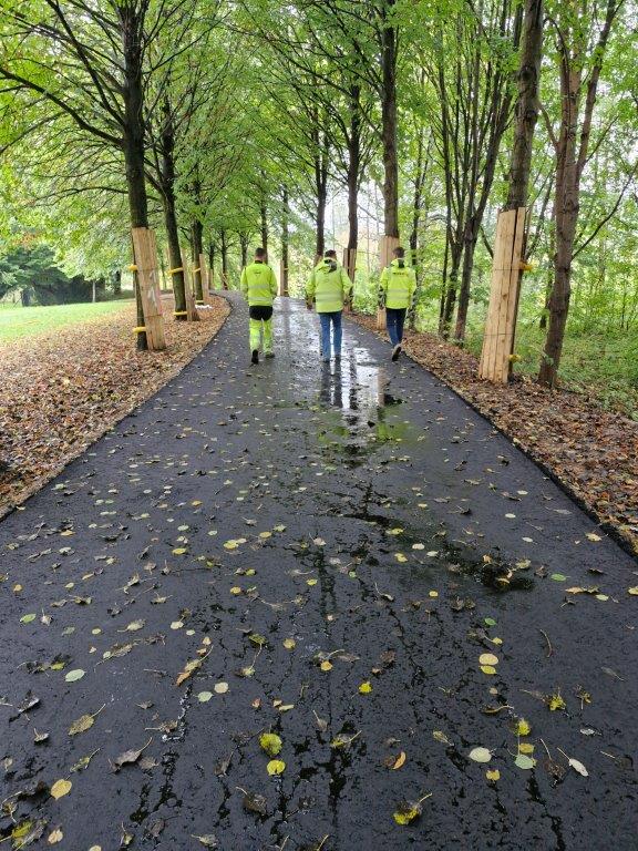 3 Personen in neongelben Arbeitsjacken laufen auf der neuen Kreisbahntrasse. Es ist endlich Bauabnahme.